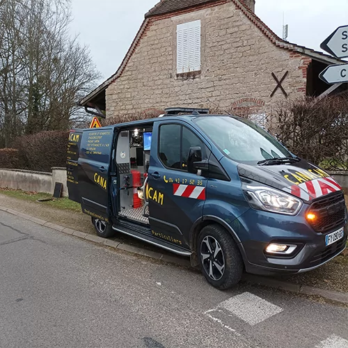 Véhicule Canacam devant une maison